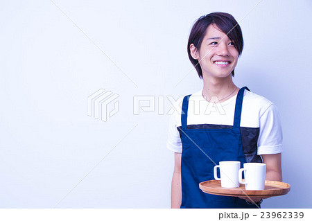 珈琲カップとお盆を持つカフェ店員の写真素材