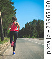 Young fitness woman running on forest trail 23965160