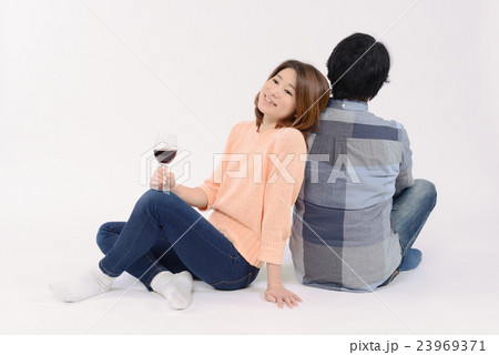 ワイングラスを持ち恋人に寄り添う若い女性 23969371