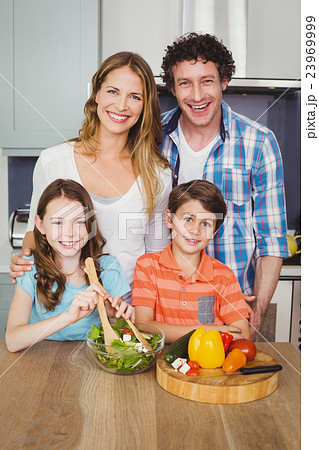 Portrait of happy family preparing vegetable salad Portrait of happy family preparing vegetable salad 23969999