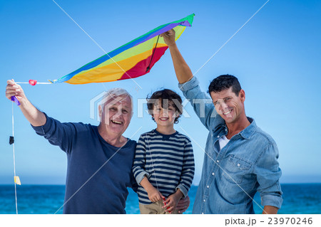 Happy multi generation family playing with a kite Happy multi generation family playing with a kite 23970246