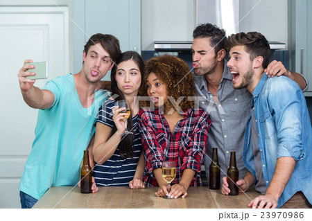 Multi-ethnic young friends making faces while taking selfie Multi-ethnic young friends making faces while taking selfie 23970986