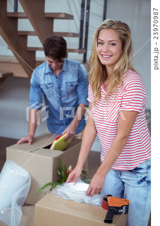 Portrait of woman unpacking bowls from box Portrait of woman unpacking bowls from box 23970987