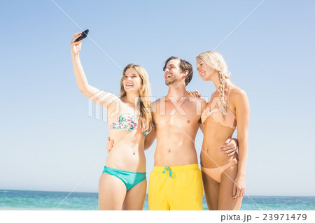 Young friends taking a selfie on the beach 23971479