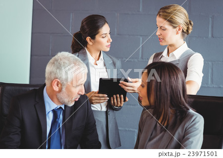 Businesspeople interacting in conference room 23971501