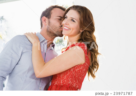 Man kissing woman on cheek 23971787