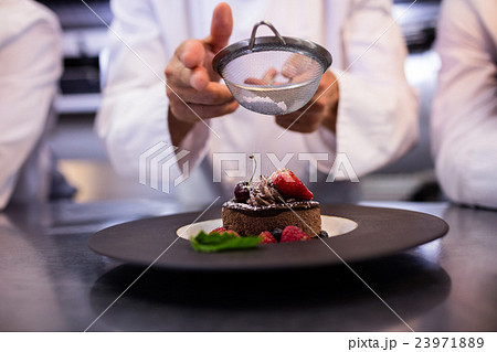 Chefs team finishing dessert plates Chefs team finishing dessert plates 23971889