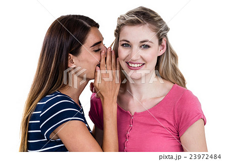 Woman telling secret to friend Woman telling secret to friend 23972484