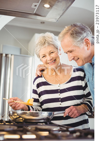 Happy senior couple cooking food in kitchen 23973117