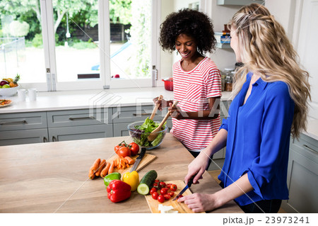 Female friends preparing food at table 23973241
