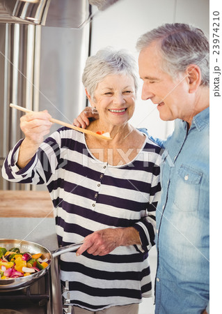Senior woman feeding food at husband 23974210