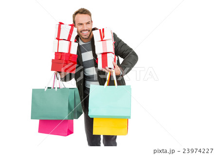Young man holding gifts and shopping bags 23974227