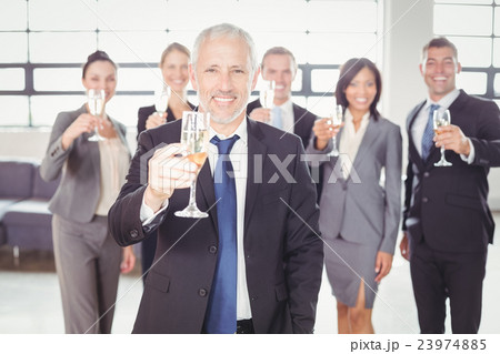 Portrait of businessman holding champagne flute 23974885