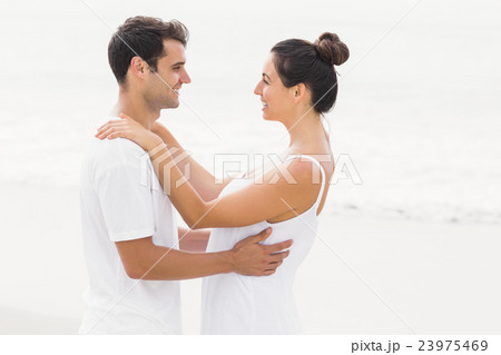 Happy couple embracing each other on the beach Happy couple embracing each other on the beach 23975469
