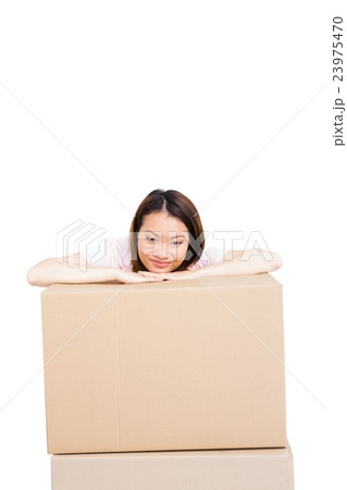 Young woman leaning on cardboard box 23975470