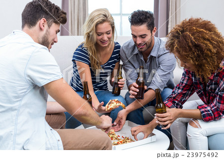 Multi-ethnic friends enjoying beer and pizza 23975492