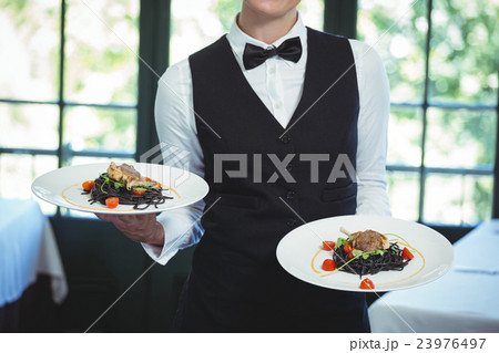 Waitress holding plates 23976497