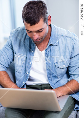 Young man using laptop 23976510