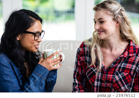 Close-up of young female friends drinking coffee 23976512