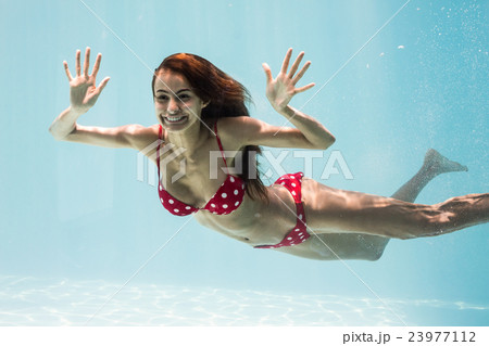Cheerful young woman swimming Cheerful young woman swimming 23977112