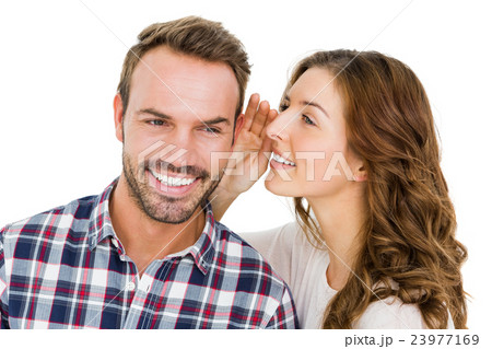 Woman whispering into mans ears 23977169