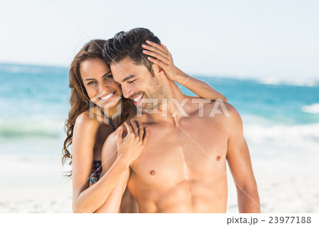 Happy couple hugging on the beach Happy couple hugging on the beach 23977188