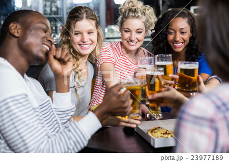 Happy friends having a drink and pizza 23977189