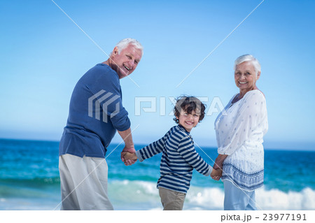 Cute boy holding his grandparents hands Cute boy holding his grandparents hands 23977191