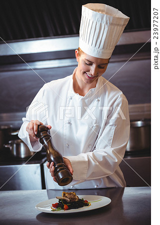 Chef sprinkling pepper on dish Chef sprinkling pepper on dish 23977207