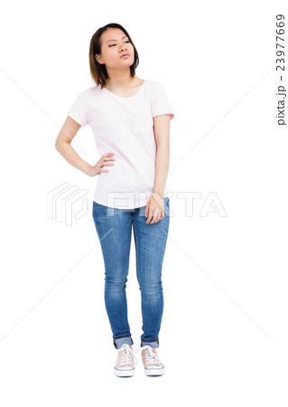 Thoughtful young woman standing with hands on hip 23977669