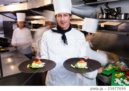 Happy head chef presenting his food plates 23977699