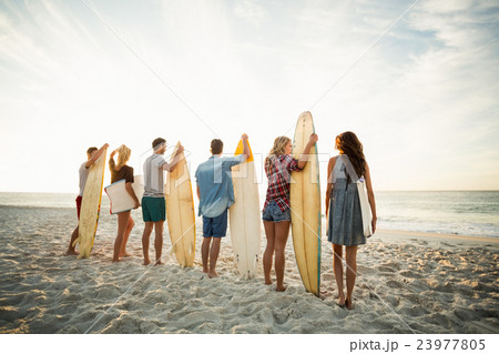 Friends holding surfboard on the beach 23977805