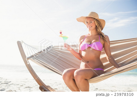Woman drinking cocktail in hammock 23978310