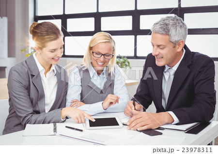 Business people discussing with client over digital tablet 23978311