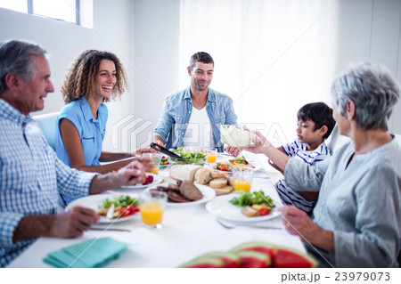 Happy family having breakfast together 23979073