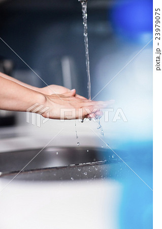 Woman cleaning hands in kitchen at home Woman cleaning hands in kitchen at home 23979075