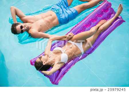 Happy couple relaxing on inflatable raft Happy couple relaxing on inflatable raft 23979245