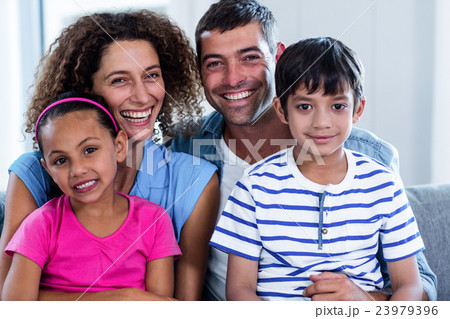 Portrait of happy family sitting together on sofa 23979396