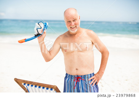 Senior man standing next to sunchair 23979868