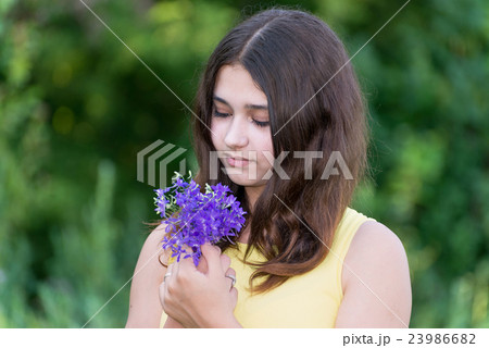Girl 14 years old looking at bouquet of 23986682