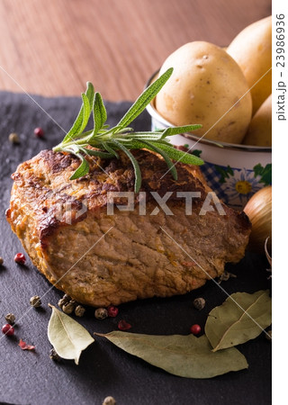 Baked piece of pork meat on slate stone 23986936