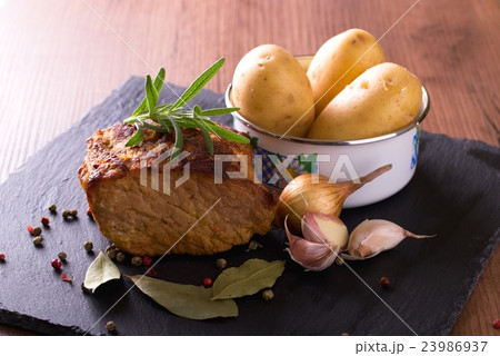 Baked pork meat with vegetable on slate stone Baked pork meat with vegetable on slate stone 23986937