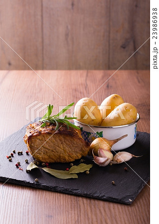 Baked portion of pork meat with rosemary branch 23986938