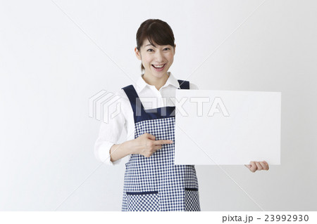 メッセージボードを持つエプロン姿の女性 メッセージボードを持つエプロン姿の女性 23992930