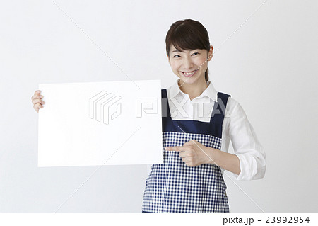 メッセージボードを持つエプロン姿の女性 メッセージボードを持つエプロン姿の女性 23992954