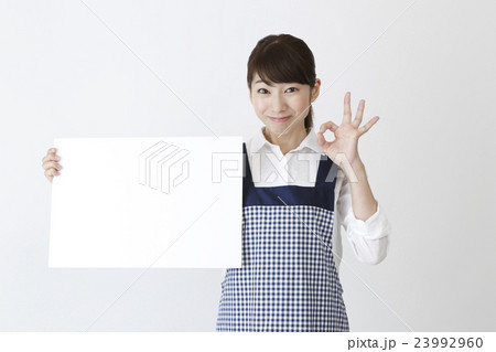 メッセージボードを持つエプロン姿の女性 メッセージボードを持つエプロン姿の女性 23992960