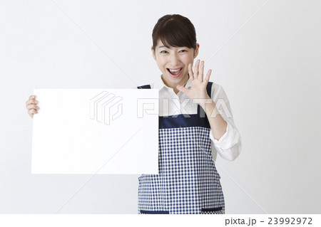メッセージボードを持つエプロン姿の女性 メッセージボードを持つエプロン姿の女性 23992972
