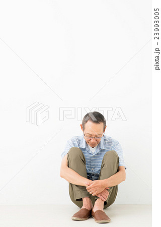 座り込むシニア男性の写真素材
