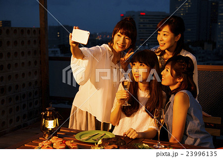 パーティー 女子会 オープンテラス スマートフォン スマホ レストラン 友達 友人 夕方 夜の写真素材