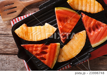 Slices of ripe watermelon and melon in a pan grill 23996748